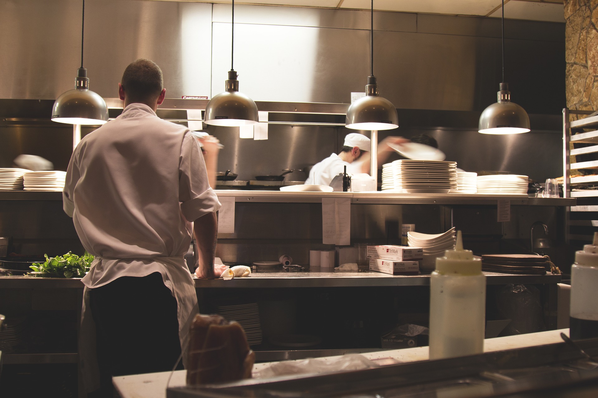 Interno cucina e chef fotografato di spalle